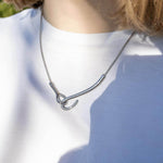 Колие от медицинска стомана, символизиращо свързаност в златисто и сребристо, елегантен дизайн.